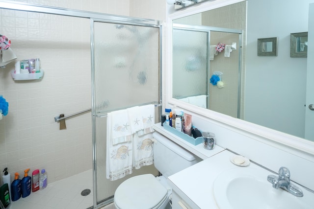 bathroom with toilet, an enclosed shower, and vanity