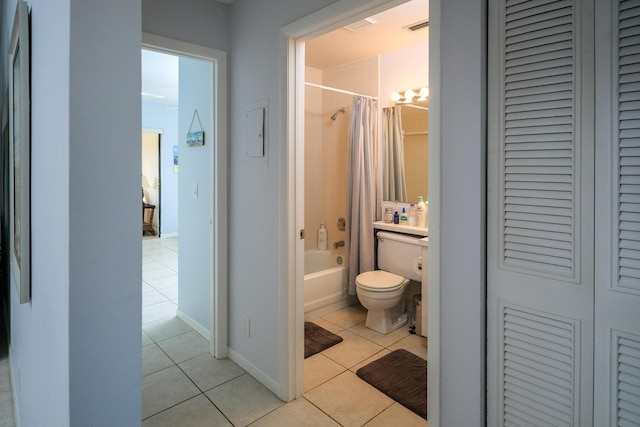 bathroom with tile patterned flooring, shower / bath combination with curtain, and toilet