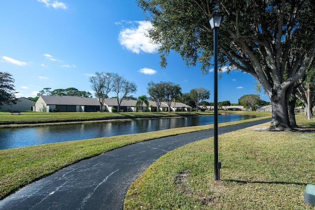 view of home's community with a lawn and a water view