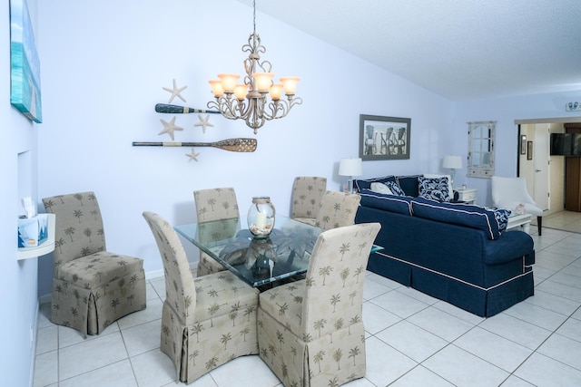 tiled dining area with a notable chandelier, lofted ceiling, and a textured ceiling