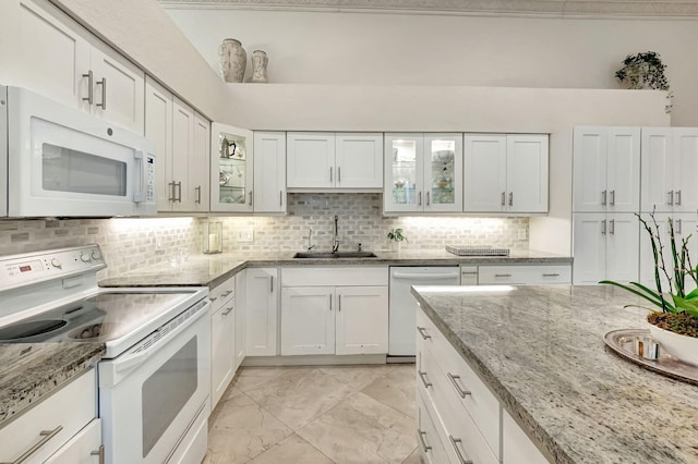 kitchen featuring sink, white appliances, white cabinetry, and tasteful backsplash