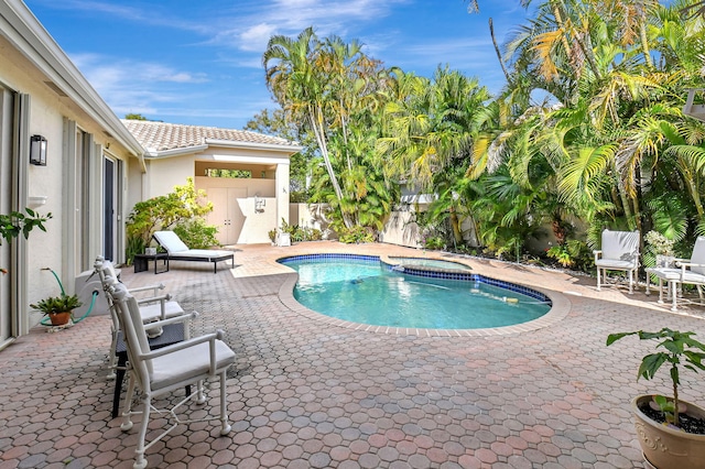 view of pool featuring a patio area and an in ground hot tub