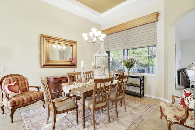 dining room featuring a towering ceiling and an inviting chandelier