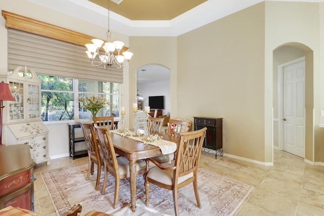 dining room with a chandelier and a raised ceiling