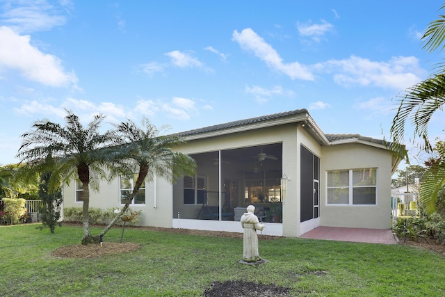 rear view of house featuring a sunroom, a yard, and a patio