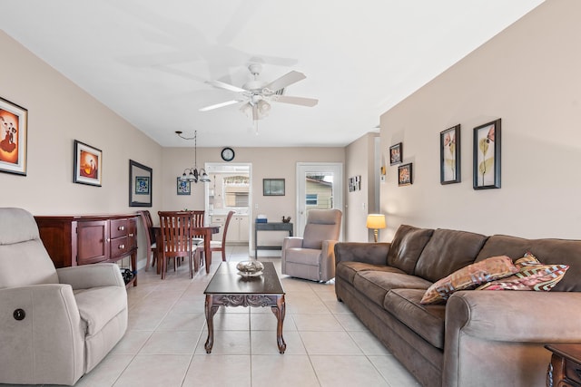 living room featuring ceiling fan with notable chandelier and light tile patterned floors