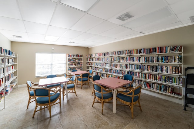 interior space with a drop ceiling and tile patterned floors