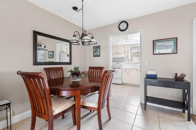 tiled dining area featuring sink and an inviting chandelier