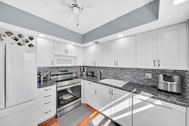 kitchen featuring white appliances, sink, ceiling fan, light wood-type flooring, and white cabinetry