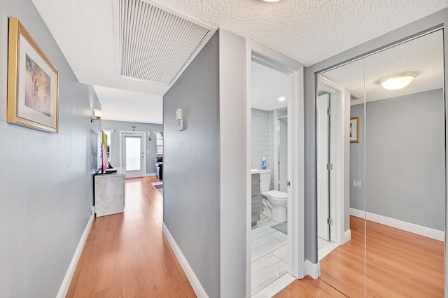 corridor featuring hardwood / wood-style flooring and a textured ceiling