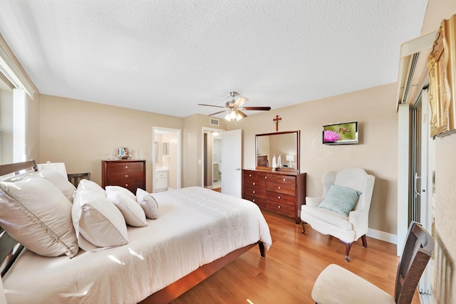 bedroom featuring ensuite bathroom, ceiling fan, a textured ceiling, and hardwood / wood-style flooring