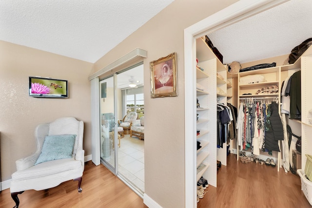 walk in closet featuring hardwood / wood-style floors and ceiling fan