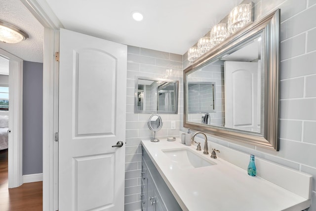 bathroom with hardwood / wood-style floors, vanity, and a textured ceiling