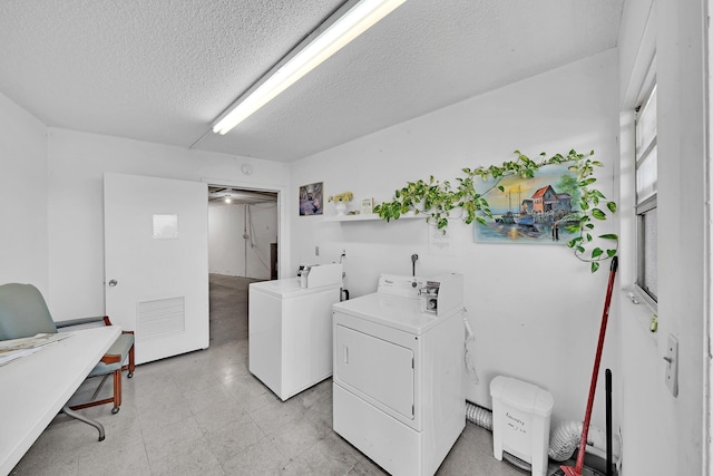 laundry room featuring washer and clothes dryer and a textured ceiling