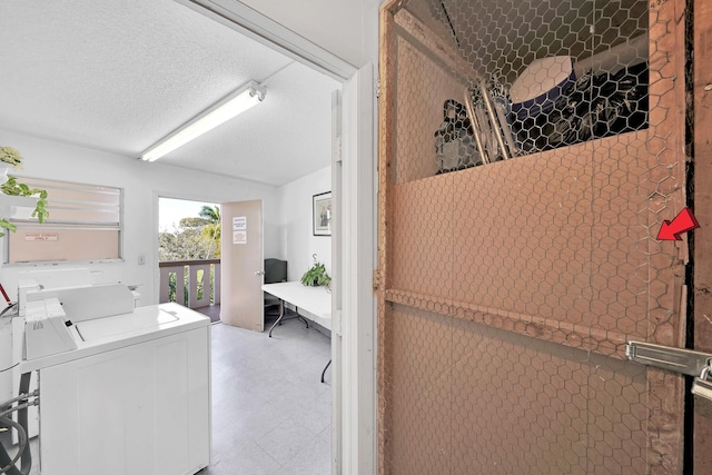 clothes washing area with a textured ceiling and separate washer and dryer