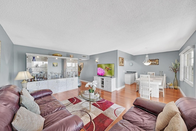 living room with a textured ceiling and light hardwood / wood-style flooring