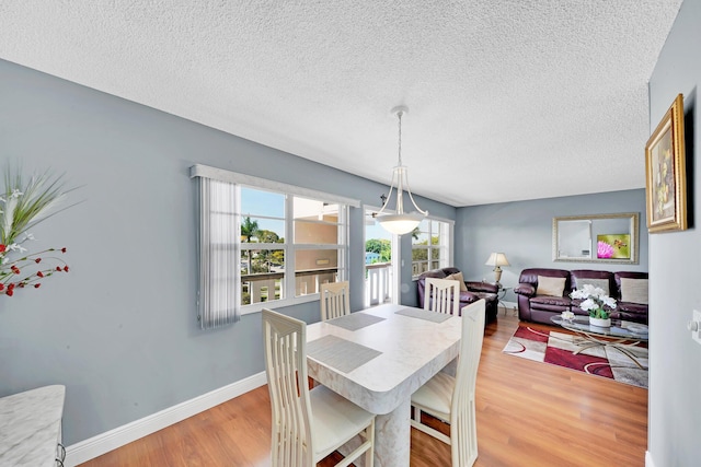 dining space featuring hardwood / wood-style floors and a textured ceiling