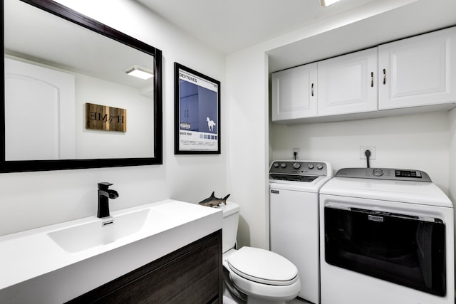 bathroom with toilet, separate washer and dryer, and vanity