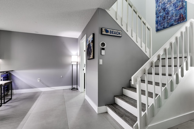 stairs featuring a textured ceiling