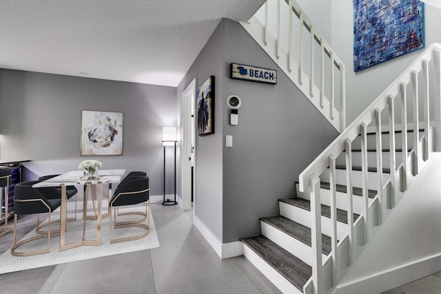 staircase featuring a textured ceiling