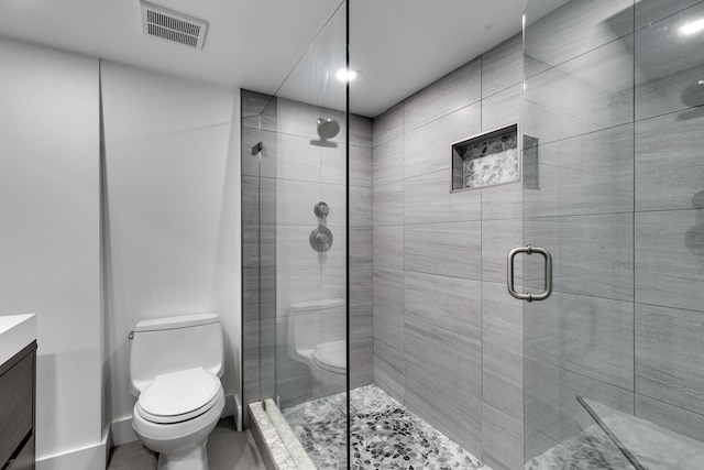 bathroom featuring a shower with door, toilet, and vanity