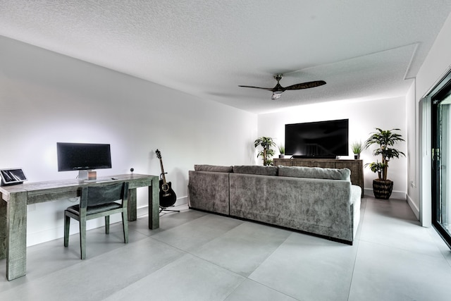 living room featuring ceiling fan and a textured ceiling