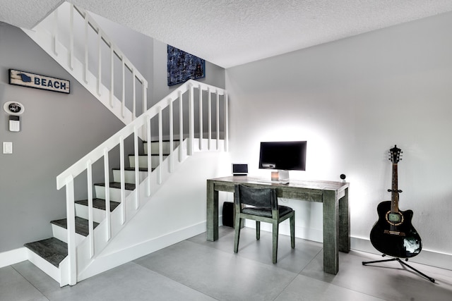 office area featuring a textured ceiling and concrete flooring