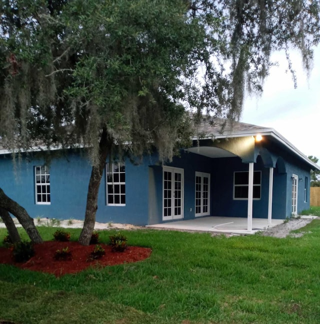 back of house with a yard, a patio area, and french doors