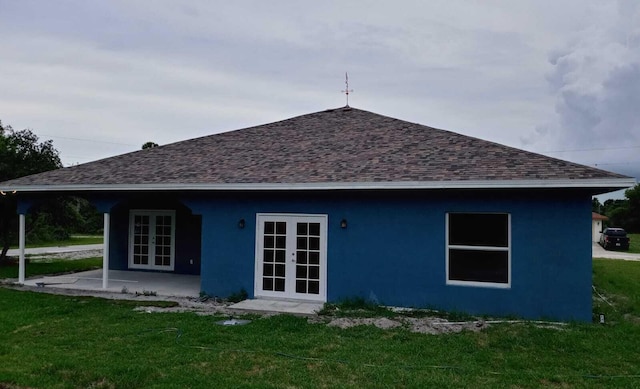 rear view of house featuring a lawn and french doors