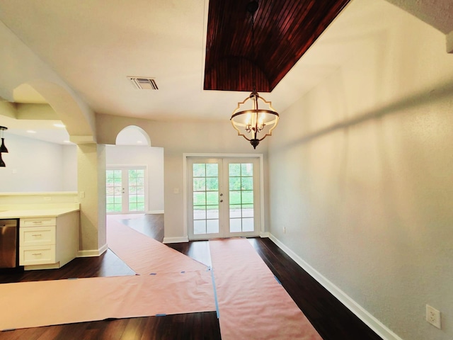 interior space with a notable chandelier, dark hardwood / wood-style flooring, and french doors