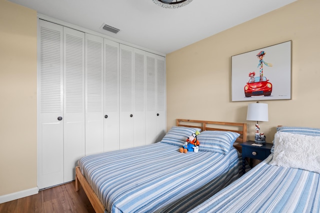 bedroom with dark wood-type flooring and a closet