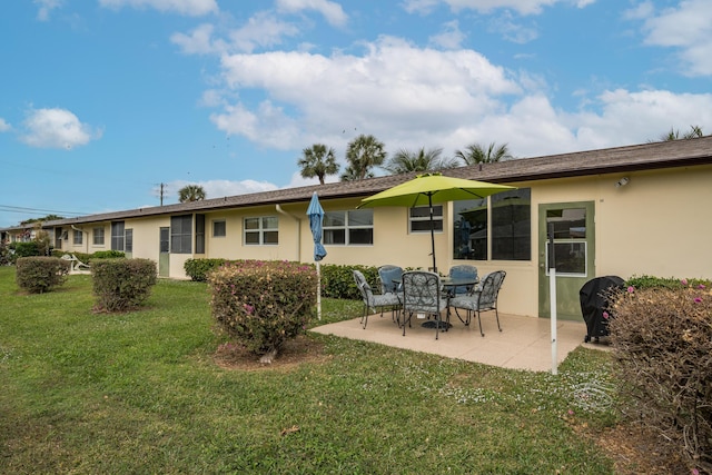 rear view of house featuring a patio area and a lawn