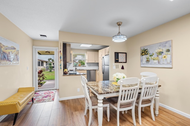 dining space featuring sink and light hardwood / wood-style flooring