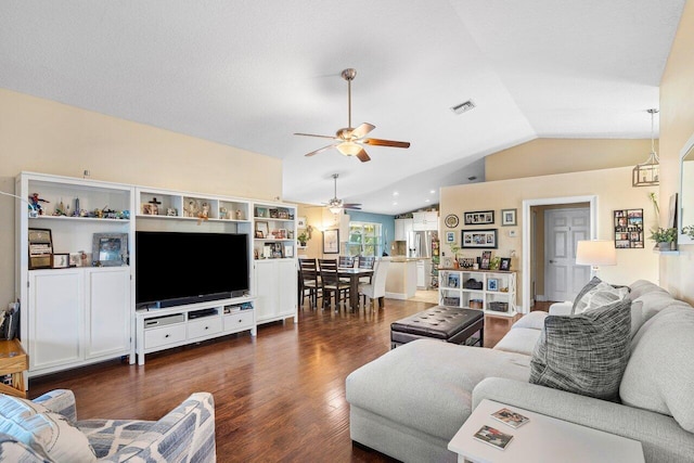 living room with ceiling fan, dark wood-type flooring, and vaulted ceiling