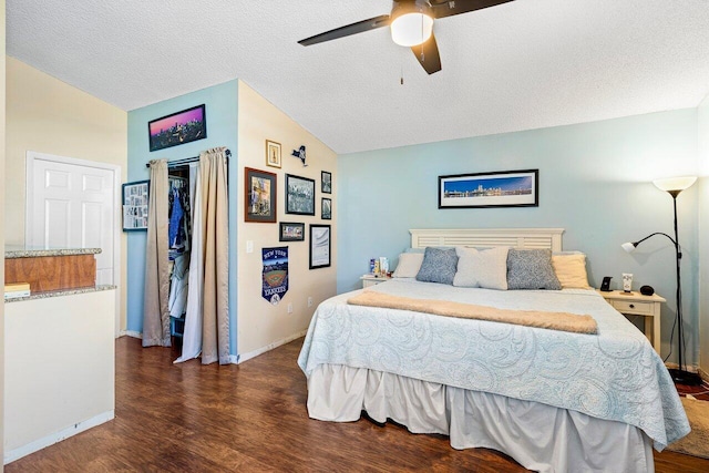 bedroom featuring a textured ceiling, ceiling fan, dark wood-type flooring, and vaulted ceiling