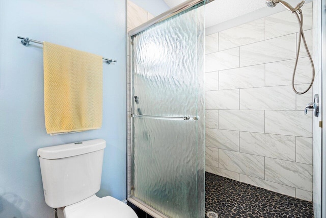 bathroom with toilet and a shower with shower door