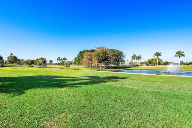 view of property's community with a water view and a yard