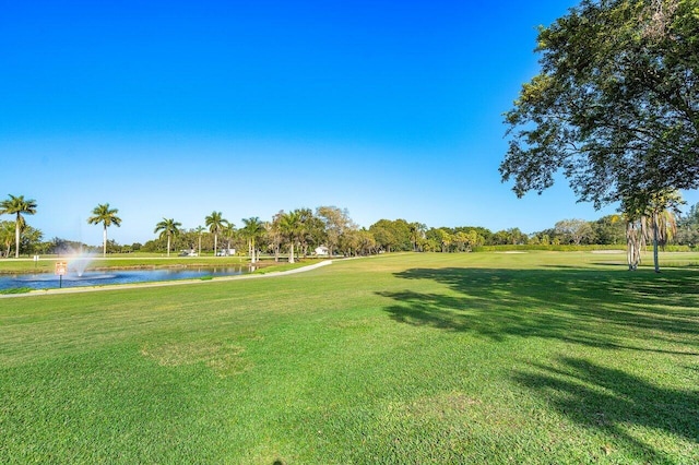 surrounding community featuring a water view and a lawn