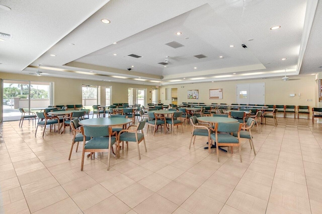 dining room featuring a raised ceiling and light tile patterned floors