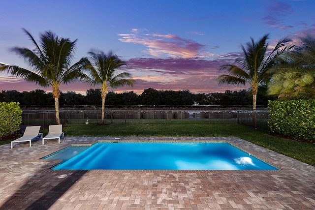 pool at dusk featuring a patio area