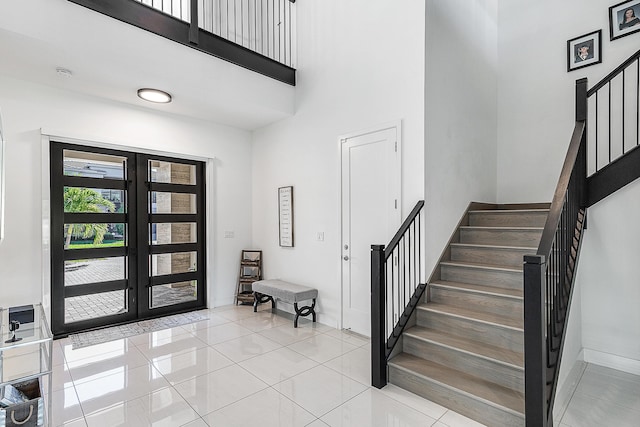 tiled entryway featuring french doors and a high ceiling