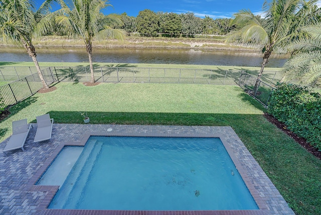 view of swimming pool featuring a water view, a patio area, and a lawn