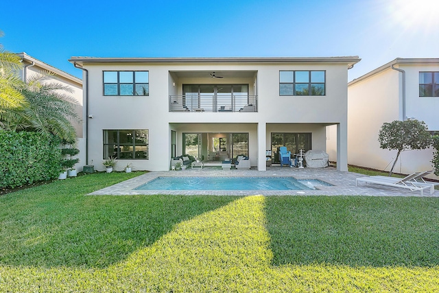 rear view of house featuring a lawn, ceiling fan, an outdoor living space, a balcony, and a patio area