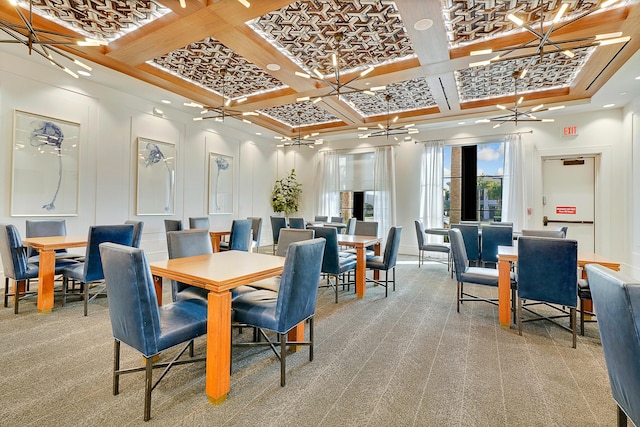 carpeted dining area featuring beamed ceiling, an inviting chandelier, and coffered ceiling