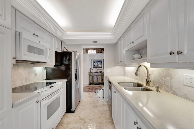 kitchen featuring white cabinetry, a tray ceiling, white appliances, ornamental molding, and sink