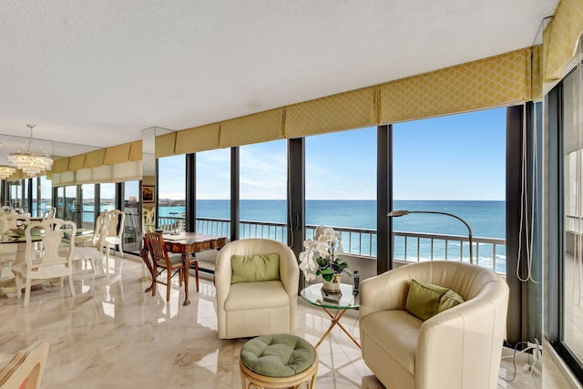 sunroom / solarium featuring an inviting chandelier, a water view, and plenty of natural light