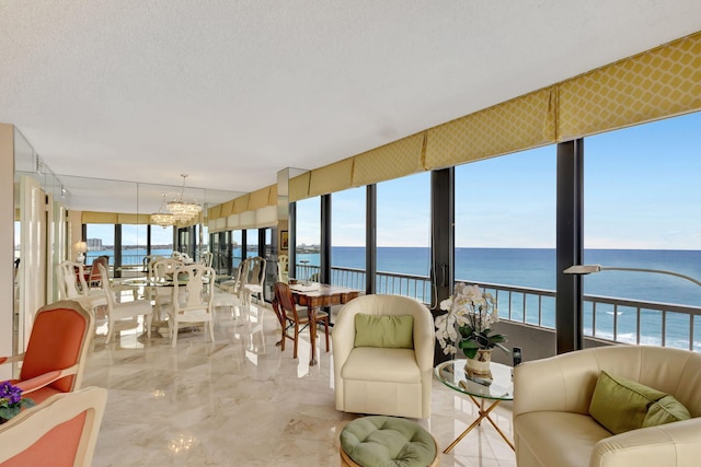 sunroom with a chandelier and a water view