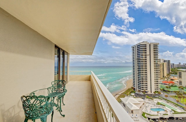 balcony featuring a water view and a beach view