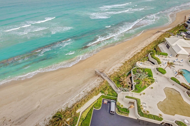 birds eye view of property with a water view and a beach view