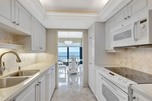 kitchen with an inviting chandelier, white appliances, a water view, white cabinets, and sink